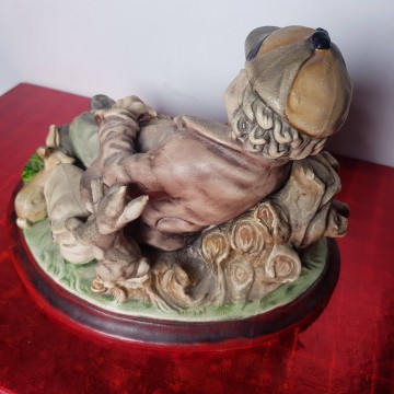 Figura de cerámica ar.ce.mi cazador con perro y conejos descansando