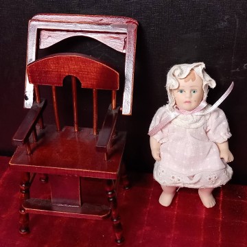 Muñeca de porcelana bebé con trona.