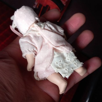 Muñeca de porcelana bebé con trona.